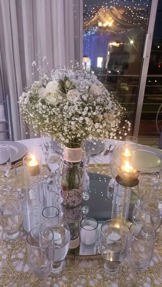Centro de mesa con flores blancas y velas encendidas