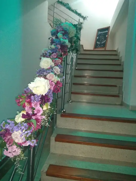 Escalera interior del salón decorada con flores